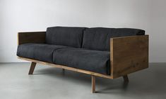 a black couch sitting on top of a wooden frame