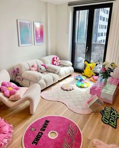 a living room filled with lots of furniture and pink rugs on top of hard wood flooring