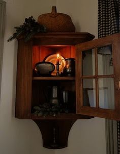 a wooden shelf with candles and other items in it