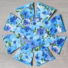 blue flowers are arranged in the center of a flower arrangement on top of a wooden table