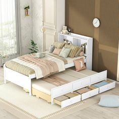 a white bed with drawers underneath it in a room next to a window and rug