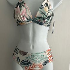 This Ruched Bikini Brief And Pleated Bikini Top From Rachel Roy Features A Floral Design, Ruched Side Detail, And Full Lining With Classic Coverage Bottom. Coral Reef Print This Halter Bikini Top From Rachel Roy Features A Solid Color Design, Removable Soft Pads, Full Lining, Deep V-Neck, Tie-Back Closure, And Halter Neck. Fabrication 82% Nylon, 18% Spandex. Internal Shelf Bra Molded Cups Hand Wash Lay Flat To Dry Nylon Spandex Coral Reef Size Medium Questions? Leave A Comment Below! Lined Tankini For Poolside, Summer Halter Neck Swimwear With Tropical Print, Summer Tropical Print Halter Neck Swimwear, Fitted Tropical Print Tankini For Beach Season, Fitted Tropical Tankini For Beach Season, Ruched Triangle Top Swimwear For Sunbathing, Tropical Fitted Swimwear For Vacation, Fitted Tropical Swimwear For Vacation, Beachwear Lined Triangle Top Swimwear