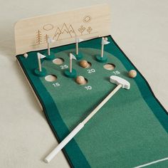 a miniature golf course with wooden tees and balls on the green mat, ready to play