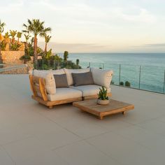 a couch sitting on top of a patio next to the ocean