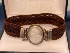 Antique Victorian 14kt cameo hair bracelet has an oval shell cameo in center which also serves as a clasp. It measures 21.5mm by 18mm. Note: safety chain is gold filled. 6.1g. Money back guarantee within 14days. Buyer pays return shipping and must be returned in original condition with box and no alterations. Victorian Brown Collectible Jewelry, Victorian Style Brown Collectible Jewelry, Elegant Adjustable Cameo Bracelets, Collectible Adjustable Cameo Jewelry, Antique Oval Cameo Bracelet, Victorian Oval Brown Jewelry, Victorian Style Oval Brown Jewelry, Victorian Brown Oval Jewelry, Brown Oval Victorian Jewelry