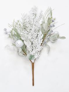 a bunch of white flowers on top of a wooden stick in front of a white wall