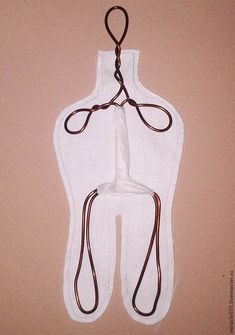 a white piece of clothing hanging from a hook on a wall with cords attached to it