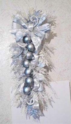 silver and white christmas decorations hanging on the wall