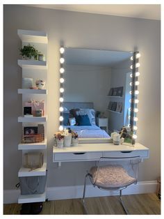 a white vanity with lights on it and a bed in the background