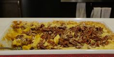 a casserole dish with pecans and cheese on top is ready to be eaten