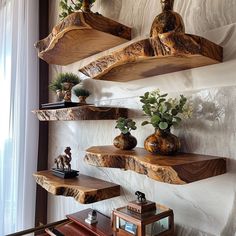 three wooden shelves with plants and vases on them