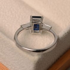 This ring features a 6*8mm emerald cut lab sapphire and sterling silver finished with rhodium. Customization is available. It is made by hand, and it will take about 7 days to finish the ring after your payment is completed. Main stone: Lab sapphire Main stone weight: Approx 1.90 ct Metal type: sterling silver finished with rhodium Accent stone: cz Customization is available, I also can make it with 14k solid gold (white or yellow or rose) and diamond accent stone, just feel free to contact me. Emerald Cut Sapphire Ring, September Birthstone Ring, Blue Gemstone Ring, Ring Emerald Cut, September Birthstone Rings, Promise Ring For Her, Blue Gemstone Rings, Ring Emerald, Promise Rings For Her