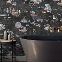 a bath tub sitting next to a wall with fish on it's side and an animal themed wallpaper behind it