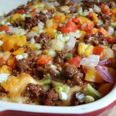 a casserole dish filled with ground beef, cheese, and vegetables is shown