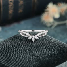 a close up view of a ring on a black cloth with flowers in the background