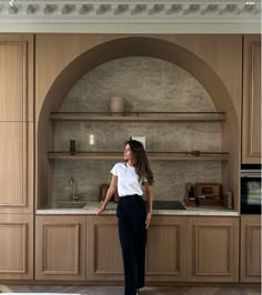 a woman standing in front of a kitchen counter