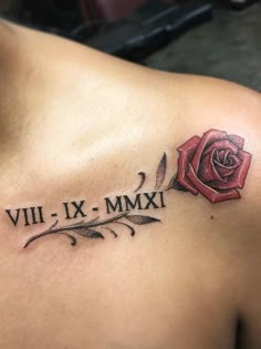 a rose tattoo on the back of a man's shoulder with roman numerals