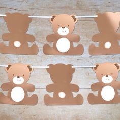 brown teddy bear cutouts hanging from clothes pins on a line with pegs in front of them