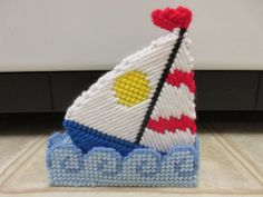 a knitted sailboat is sitting on the floor