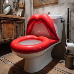 a white toilet with red lips painted on it