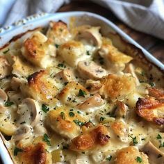 a casserole dish with chicken, mushrooms and cheese in it on a wooden table