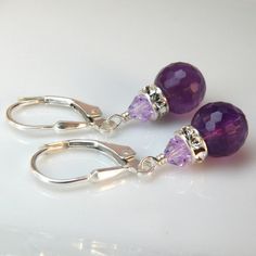 Gorgeous purple amethyst gemstones make for a beautiful pair of earrings. These finely faceted amethysts refract more light and have more added sparkle. Gorgeous AAA quality gemstones are accented with Swarovski crystal rhinestone crowns for more dazzle.This earring length is perfect to be worn everyday from the office cube to afterwards at happy hour. A fabulous genuine stone pair of earrings to gift for your bridesmaids on your wedding day.Earring Details:- Amethyst gemstone is 8 mm round and Elegant Purple Teardrop Gemstone, Elegant Amethyst Gemstones For Gift, Elegant Amethyst Gemstones As A Gift, Elegant Purple Briolette Earrings, Purple Amethyst Teardrop Crystal Earrings, Purple Crystal Earrings For Wedding, Amethyst Gemstone Crystal Drop Earrings, Faceted Lavender Teardrop Jewelry, Faceted Lavender Briolette Jewelry