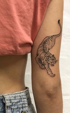 a woman's arm with a tiger tattoo on the left side of her body