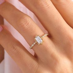 a woman's hand with a diamond ring on top of her finger and an engagement band