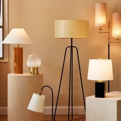 three lamps are sitting on pedestals next to each other