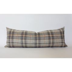 a plaid pillow sitting on top of a white table