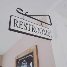 there is a sign that says restrooms hanging from the ceiling