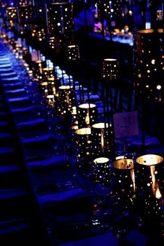 many lit candles are lined up in rows