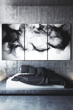 three black and white paintings on a wall above a bed