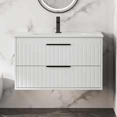 a white bathroom vanity with a round mirror above it