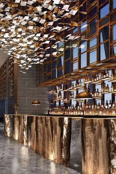 a bar with lots of bottles hanging from the ceiling and wooden bars on each side