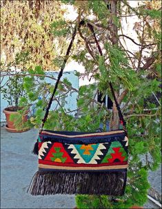 a colorful purse hanging from a tree branch