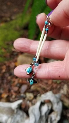 a person is holding an item in their hand with beads and charms attached to it