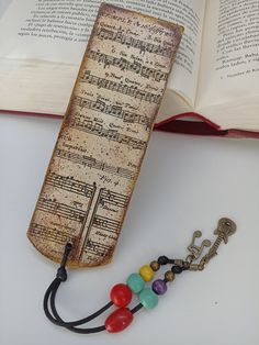 an open book with music notes and beads on it