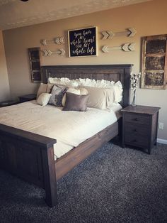 a bedroom with a bed, nightstands and pictures on the wall above it's headboard