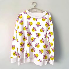 Elevate your casual style with our Cowboy Happy Face Printed All Over Sweatshirt! This eye-catching sweatshirt is a playful addition to your wardrobe, featuring a whimsical design that is sure to turn heads. Crafted from soft and cozy fabric, this white sweatshirt boasts an all-over print of smiley faces wearing charming cowgirl hats on both the front and back. The unique design adds a touch of fun and personality to your look, making it perfect for adding a dose of cheer to your everyday outfit Oversized Graphic Print Kawaii Tops, Casual Long Sleeve Sweatshirt With Cartoon Print, Oversized Kawaii Tops With Graphic Print, Trendy Long Sleeve Sweater With Cartoon Print, Trendy Cartoon Print Tops For Fall, Casual Long Sleeve Cartoon Print Sweatshirt, Trendy Long Sleeve Cartoon Print Sweater, Trendy Winter Tops With Cartoon Print, Winter Cartoon Print Tops For Loungewear