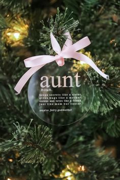 an ornament hanging from the top of a christmas tree with pink ribbon on it