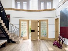 an entryway with wooden floors and white walls