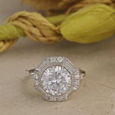 an antique style diamond ring sits on a table