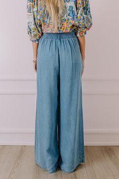 - Go with this flow in these trendy pants! - Unlined chambray material - A waistline with an elastic back, belt loops, and a removable tie closure belt - Pleated details on front - Functional side pockets - A relaxed silhouette that ends in wide floor length hemlines Spring Washed Pants With Loosely Fitted Hips, Summer Relaxed Fit Medium Wash Pants, Spring Relaxed Fit Medium Wash Pants, Summer Medium Wash Washed Pants, Versatile Denim Blue Bottoms With Elastic Waistband, Medium Wash Loose Fit Jeans For Summer, Non-stretch Light Wash Pants, Trendy Paperbag Waist Pants With Elastic Waistband, Denim Blue Tencel Straight Leg Bottoms