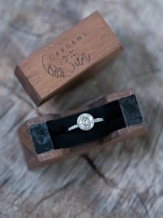 an engagement ring sits in a wooden box