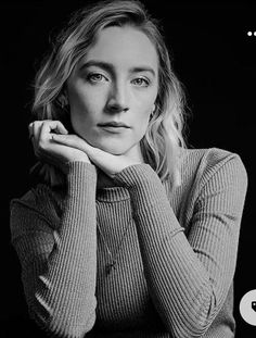 a black and white photo of a woman with her hand on her chin looking at the camera