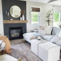 a living room filled with furniture and a fire place under a mirror on the wall