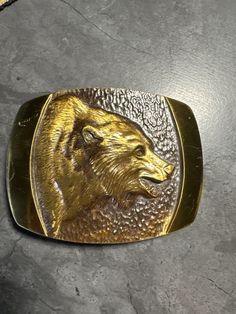 This vintage belt buckle is in good condition with a few scratches. Please refer to the listing photos. Measures: 3.2" by 2.5" Fits a belt width up to: 1.75" Vintage Gold Belt Buckles As Gift, Vintage Brass Buckle Belt Buckles Collectible, Vintage Gold Belt Buckles For Collectors, Collectible Antique Gold Belt Buckles, Collectible Gold Antique Belt Buckles, Gold Antique Buckle Vintage Belt Buckles, Gold Antique Buckle Vintage Belt Buckle, Gold Antique Belt Buckles For Collectors, Gold Antique Buckle Vintage Belt