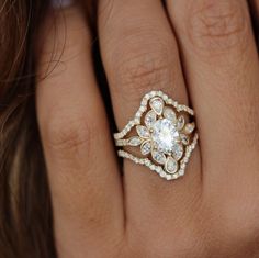 a woman's hand with a diamond ring on top of her finger and an engagement band