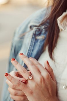 a woman with red nails and a ring on her finger